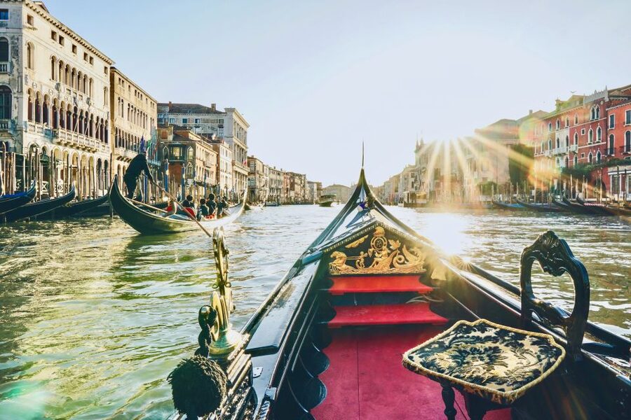 A gondola turning onto the Grand Canal with the light behind it